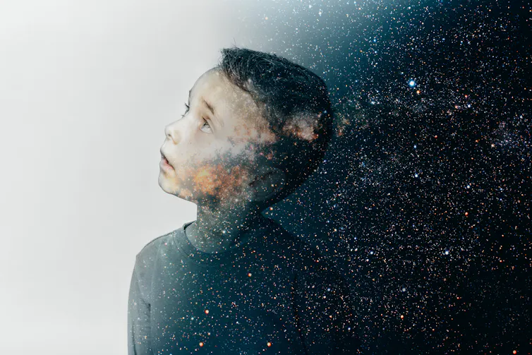 Young boy against cosmic background.