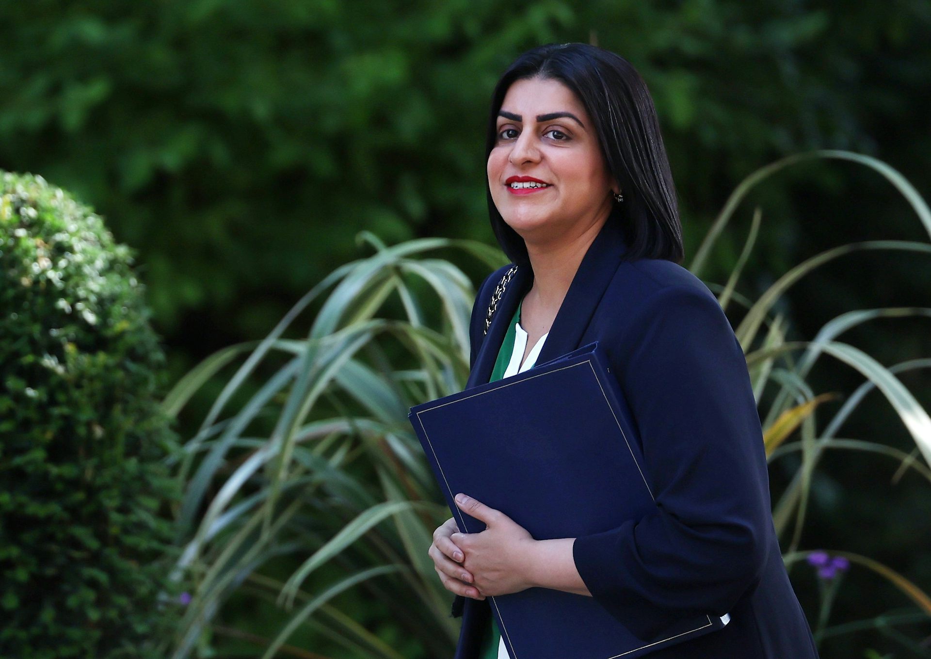 Shabana Mahmood walks with a blue folder