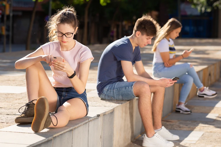 Des adolescents concentrés sur leur téléphone