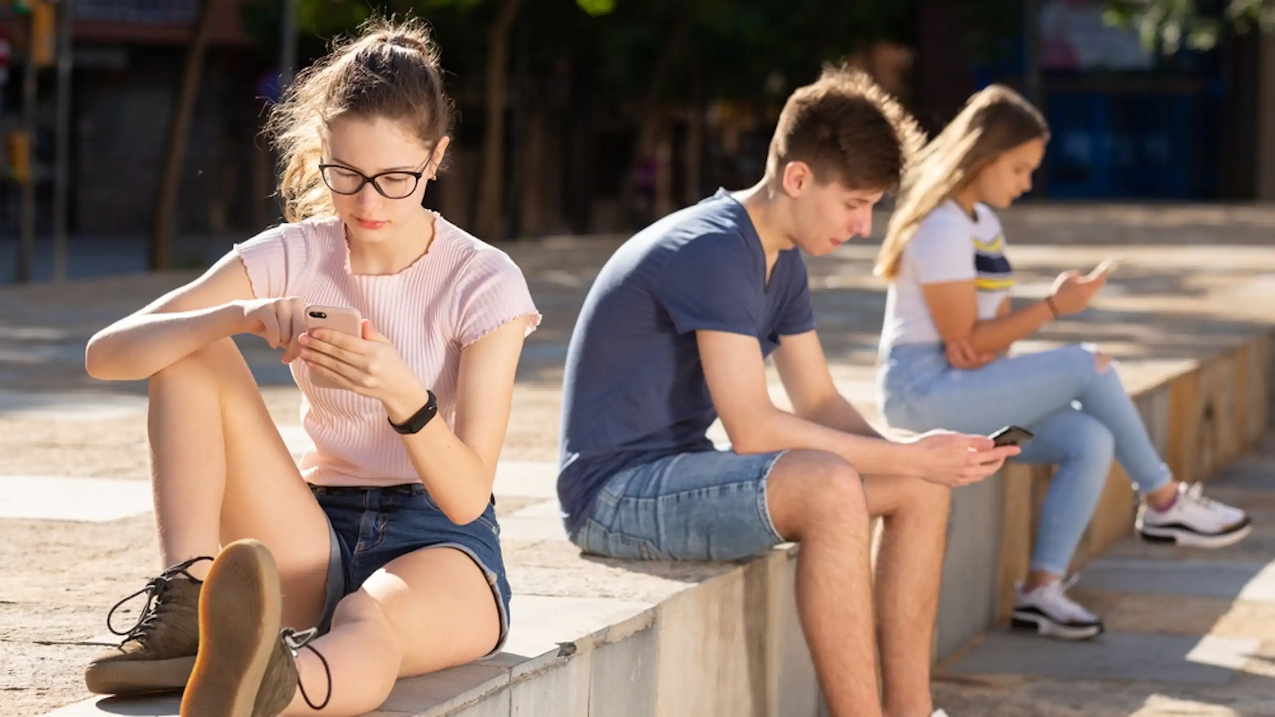 Des adolescents concentrés sur leur téléphone