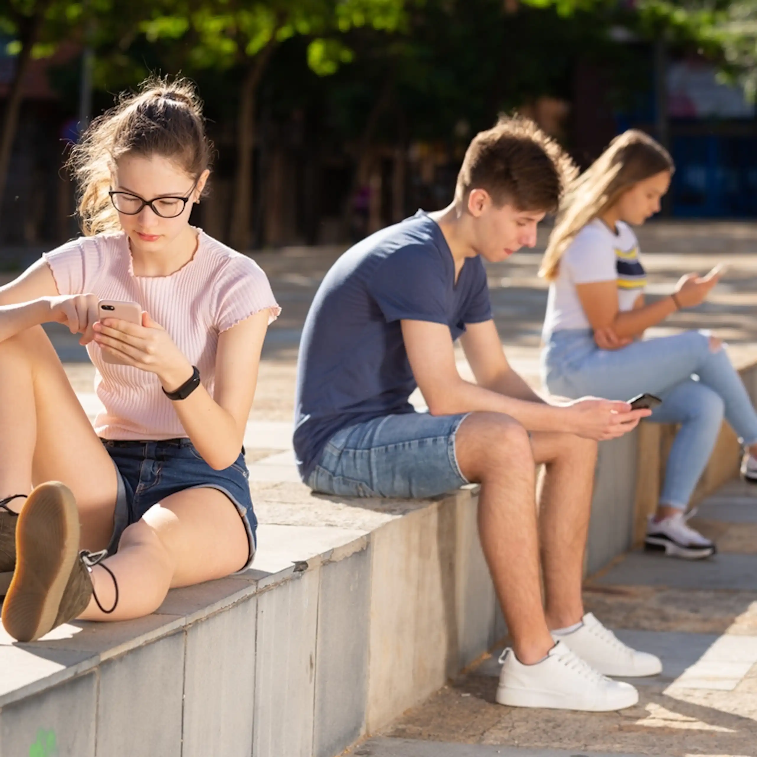 Des adolescents concentrés sur leur téléphone