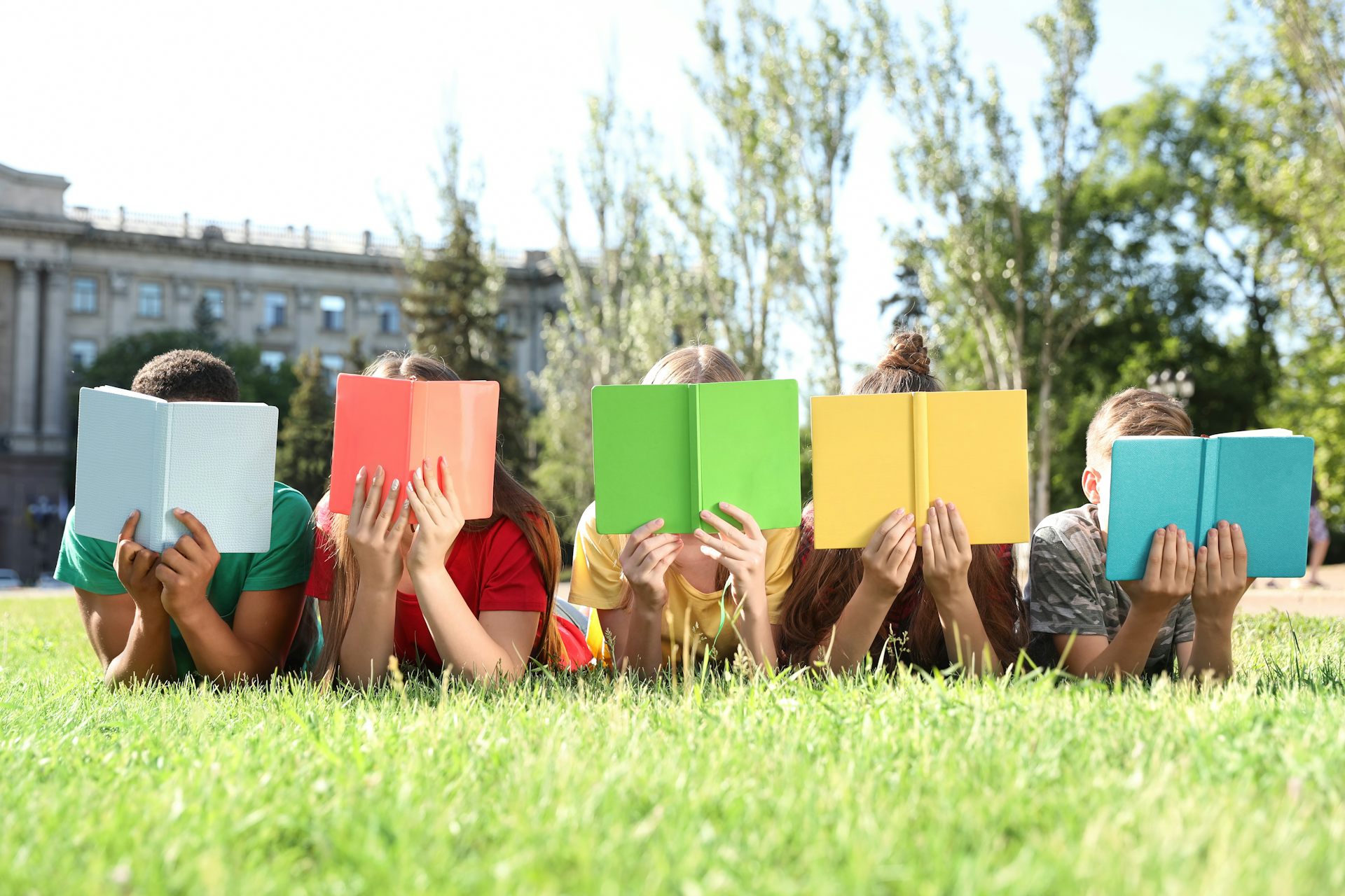 Niños leyendo libros con tapas coloridas