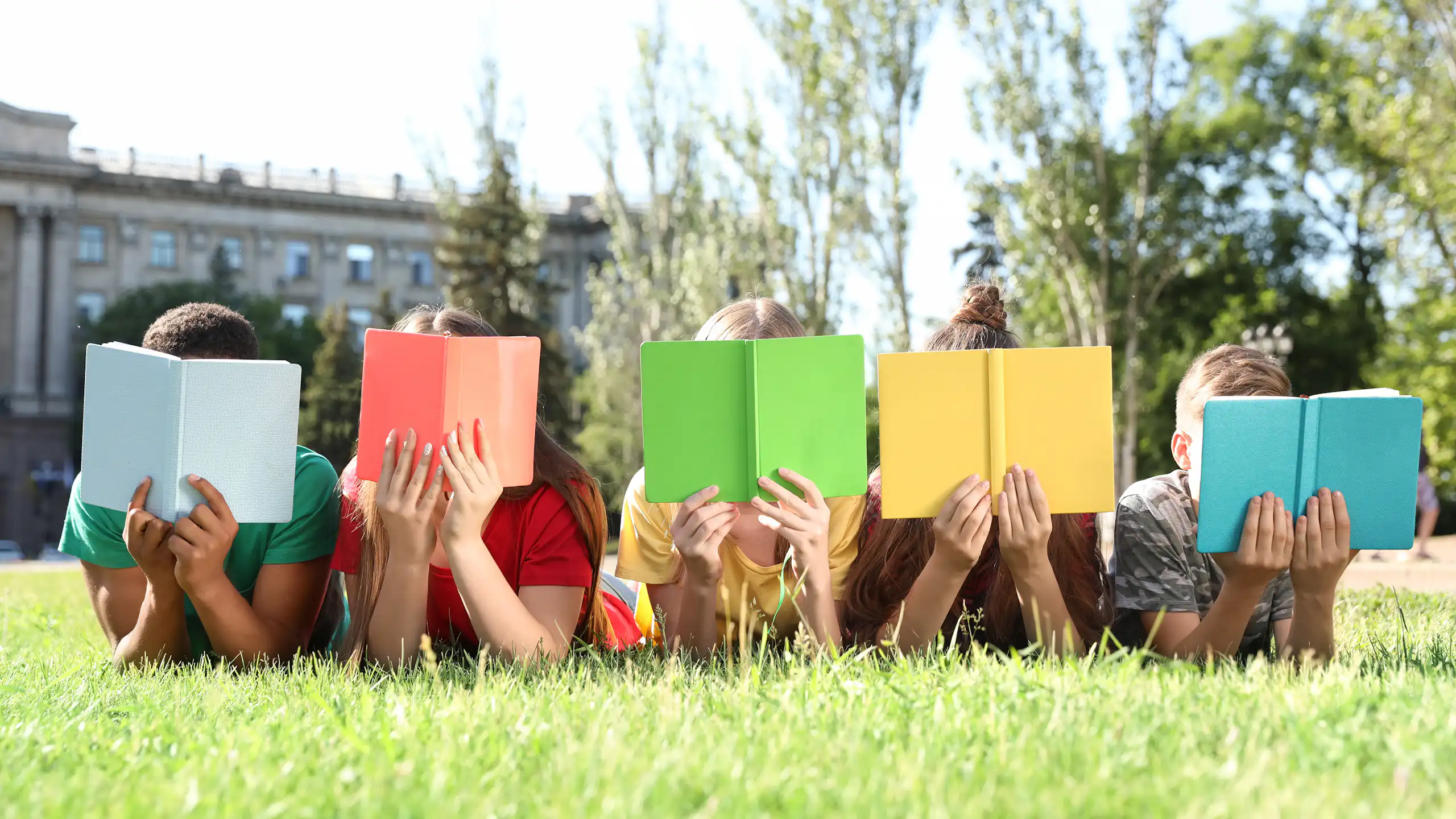 Niños leyendo libros con tapas coloridas