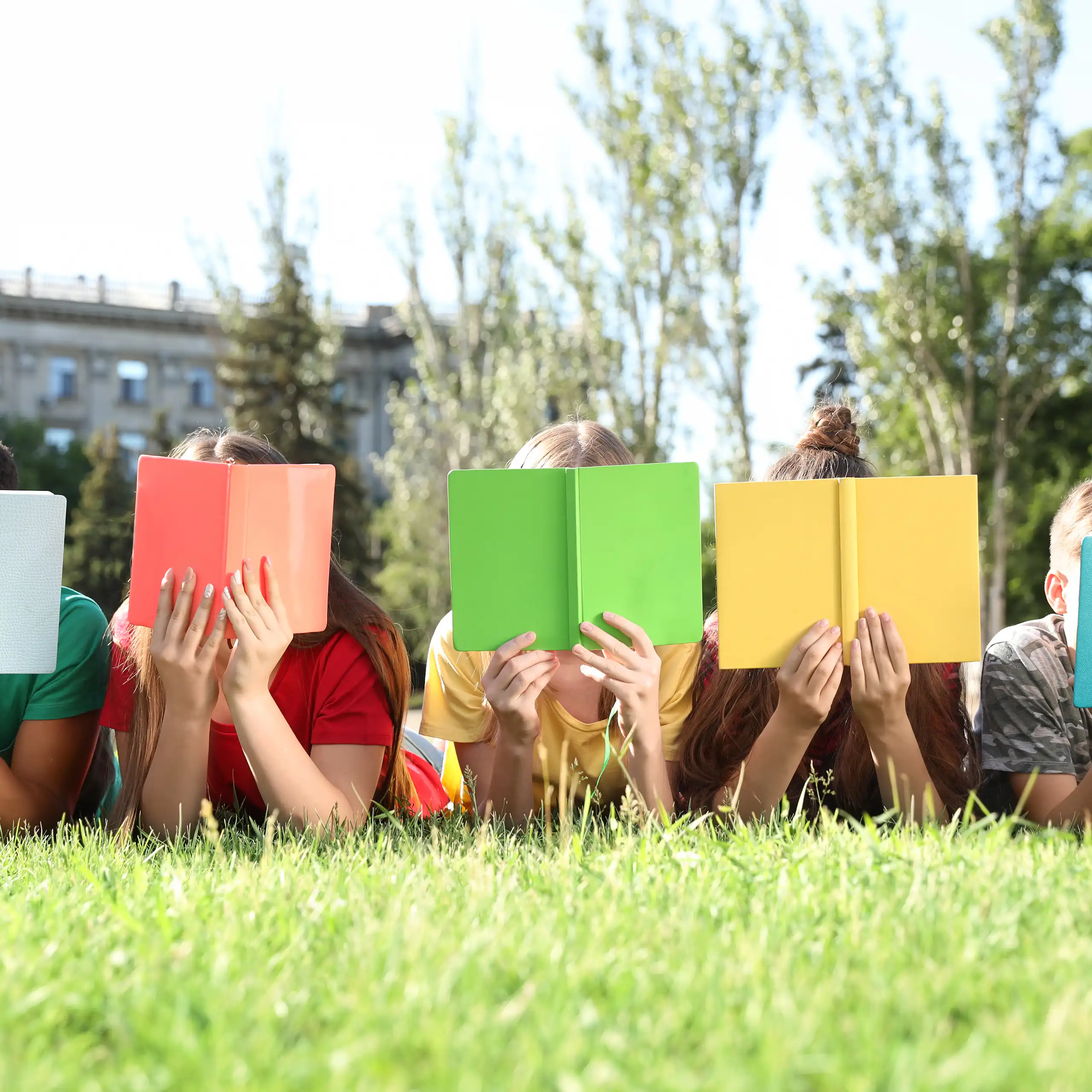 Niños leyendo libros con tapas coloridas