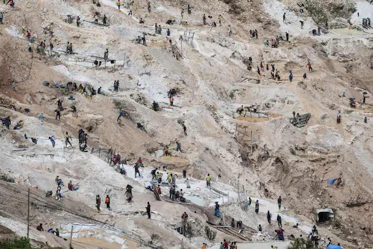 An aerial view of dozens of people working at a mining quarry.