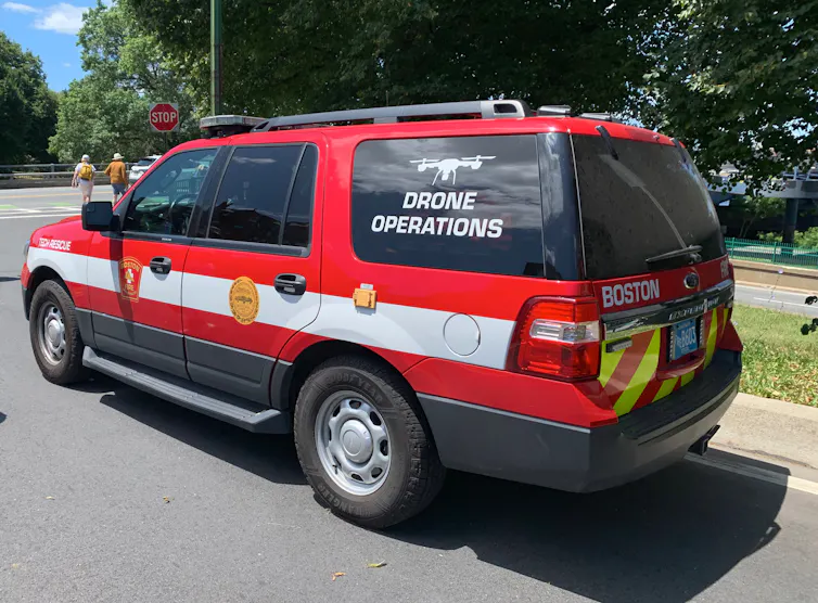 a large red SUV with a white horizontal stripe and symbols and lettering along the side