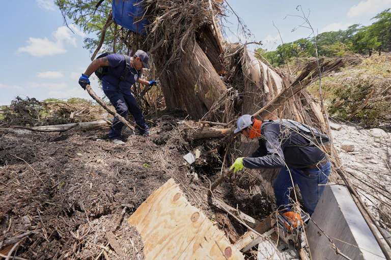 two men search through piles of debris