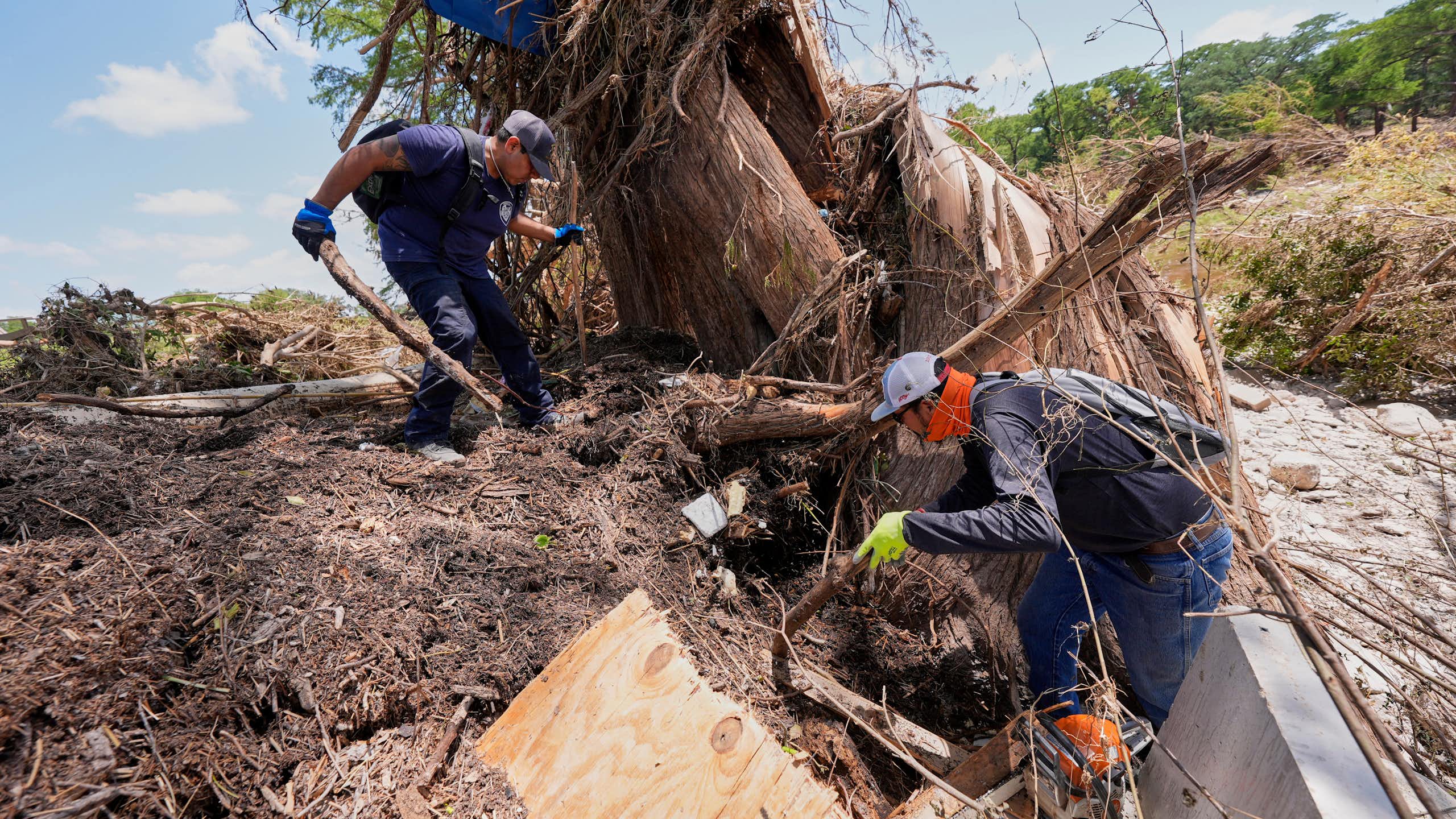 two men search through piles of debris