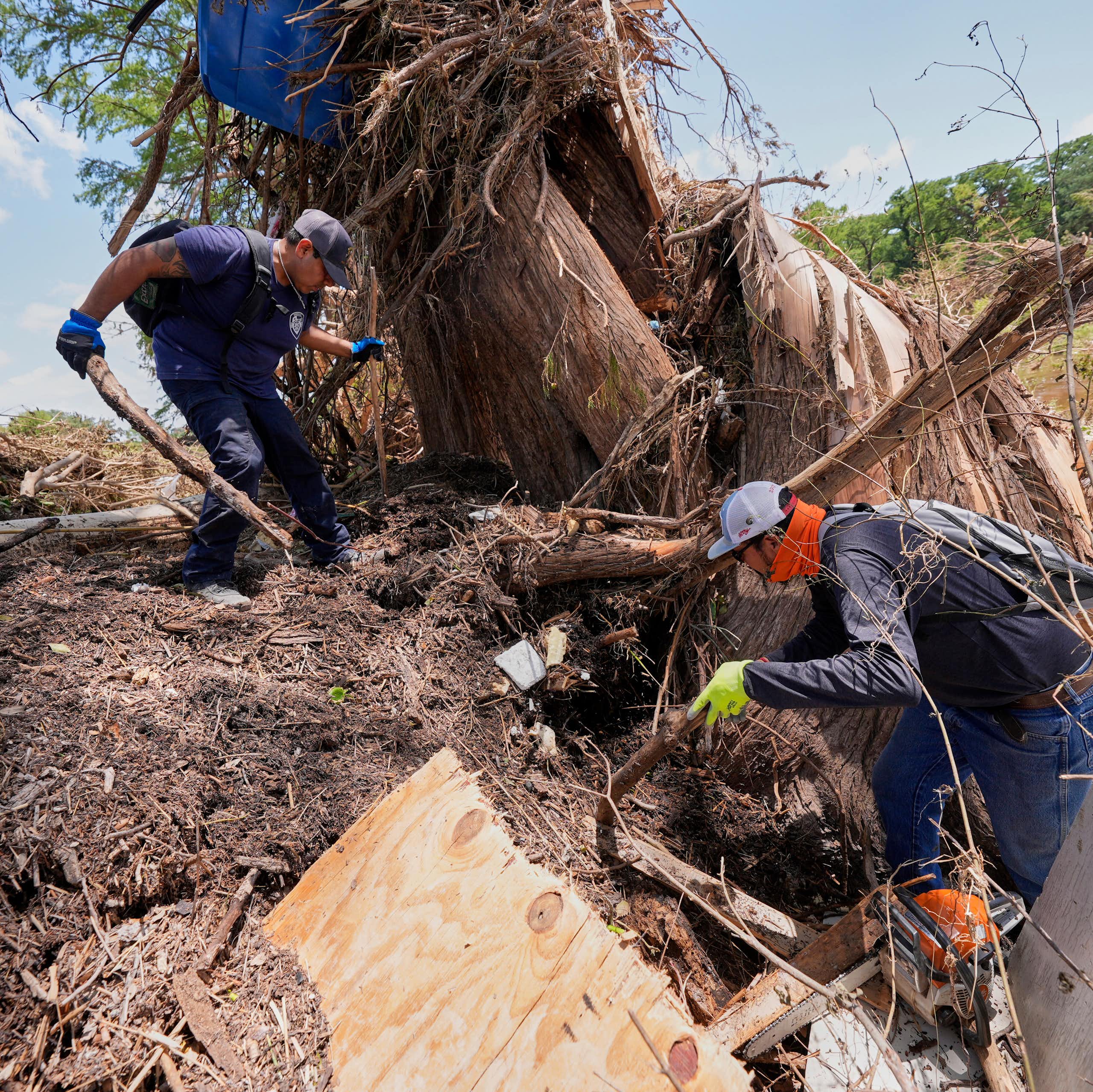 two men search through piles of debris