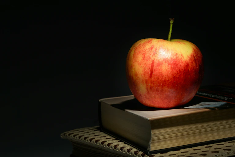 Shadowy image of an apple on top of a book