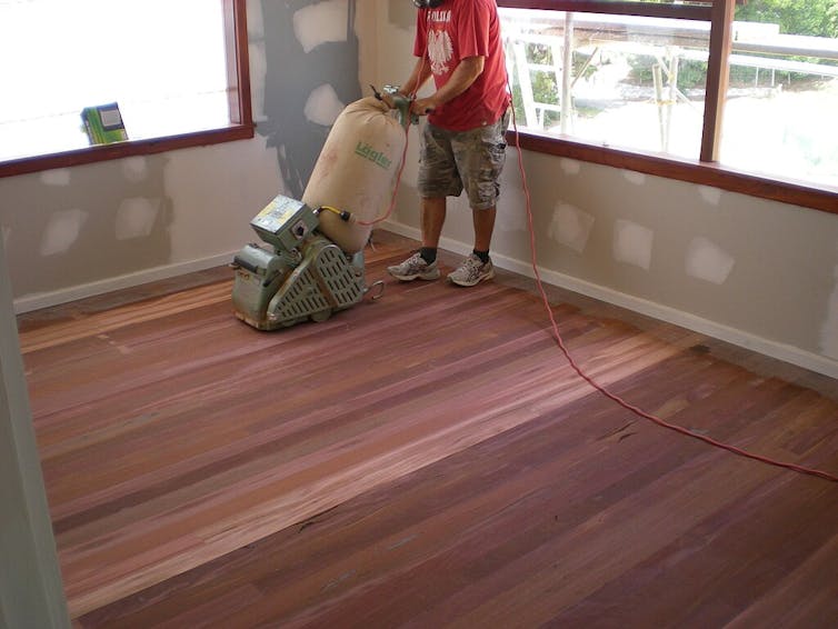 a man works on timber floor