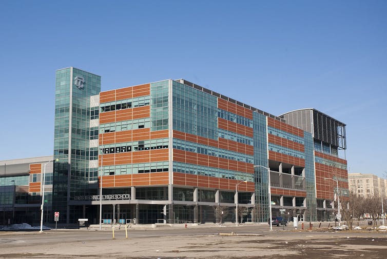 A modern-looking multi-story building made from glass and red cladding materials