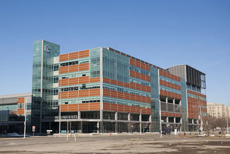 A modern-looking multi-story building made from glass and red cladding materials