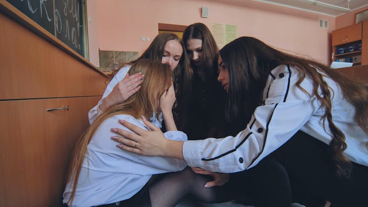 Distressed teenage girls hugging