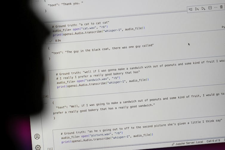 A facial silhouette seen near a screen with writing.