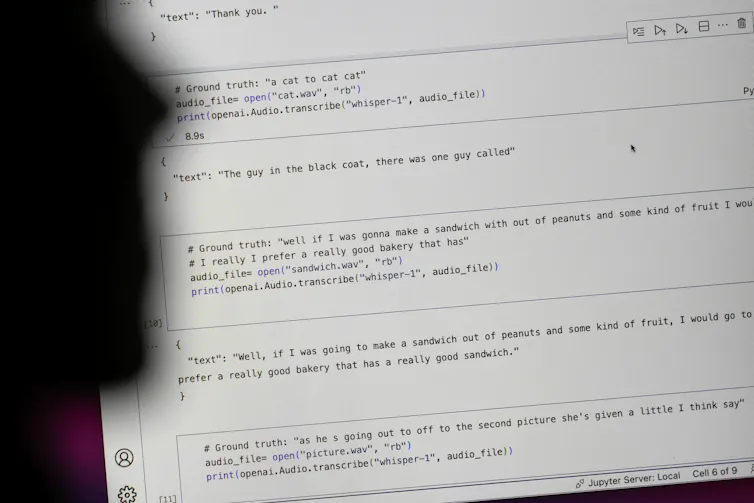 A facial silhouette seen near a screen with writing.