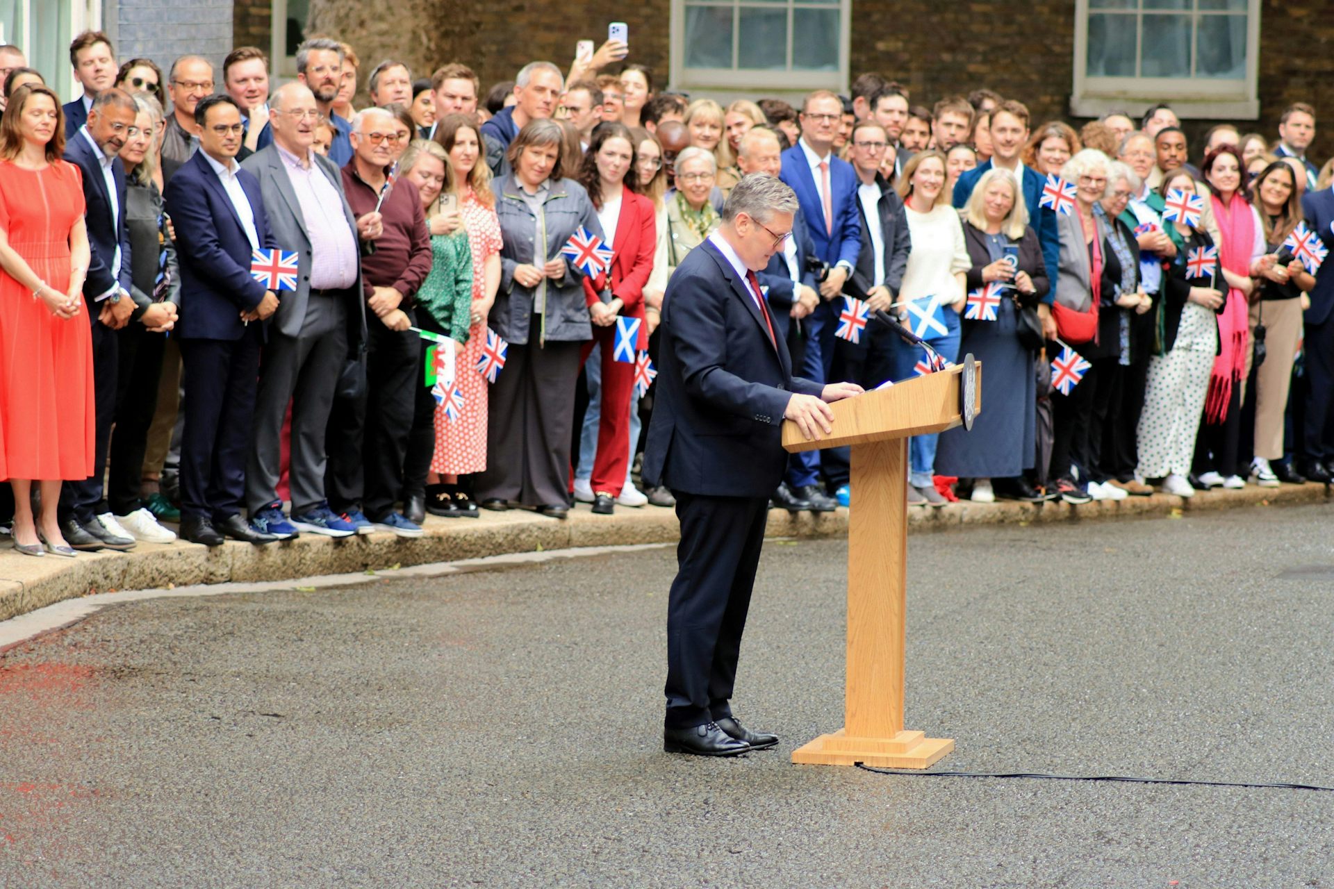 Keir Starmer at a lecturn on Downing Street in front of a crowd.