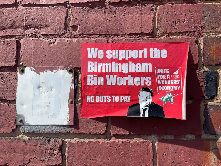 A Unite poster on a wall saying 'we support the Birmingham bin workers'
