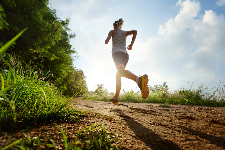 Woman running on a rural road during sunset