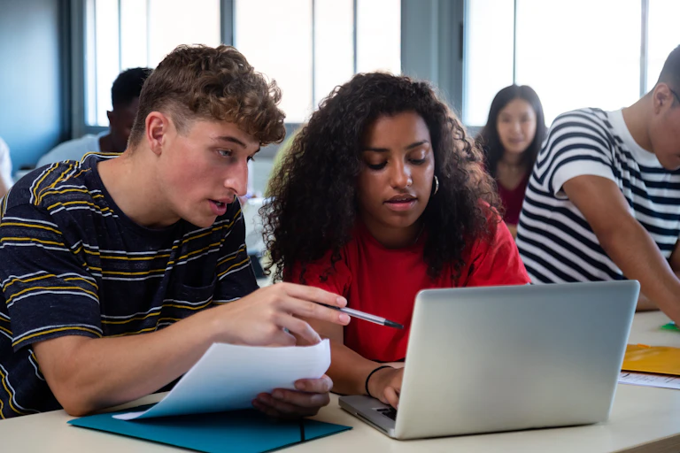 Girl and boy in class looking at computer