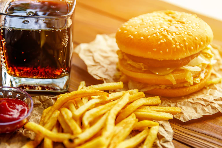 Soft drink with burger and fries.