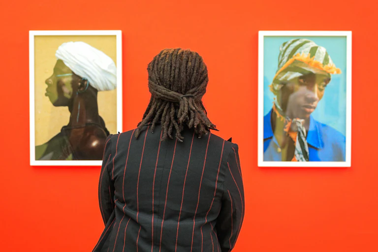 woman looks at two photographs of black women