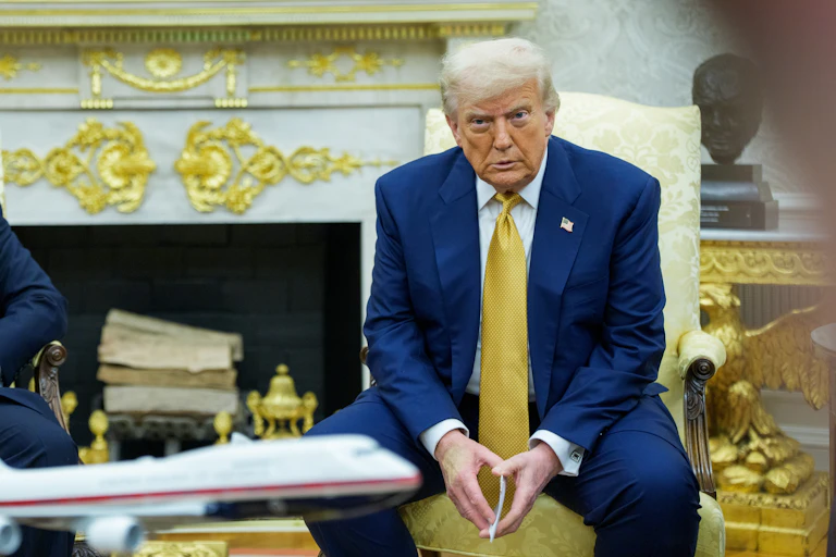 Donald Trump sat in a meeting with his hands clasped together.