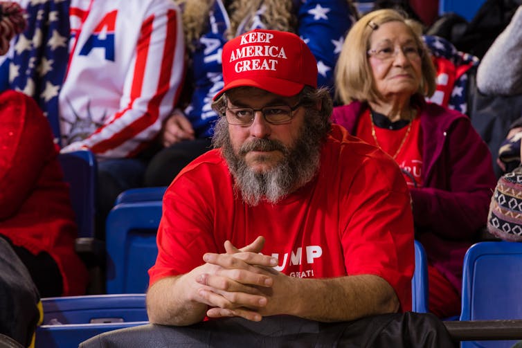 A Trump supporter sporting a red 'Keep America Great' hat.