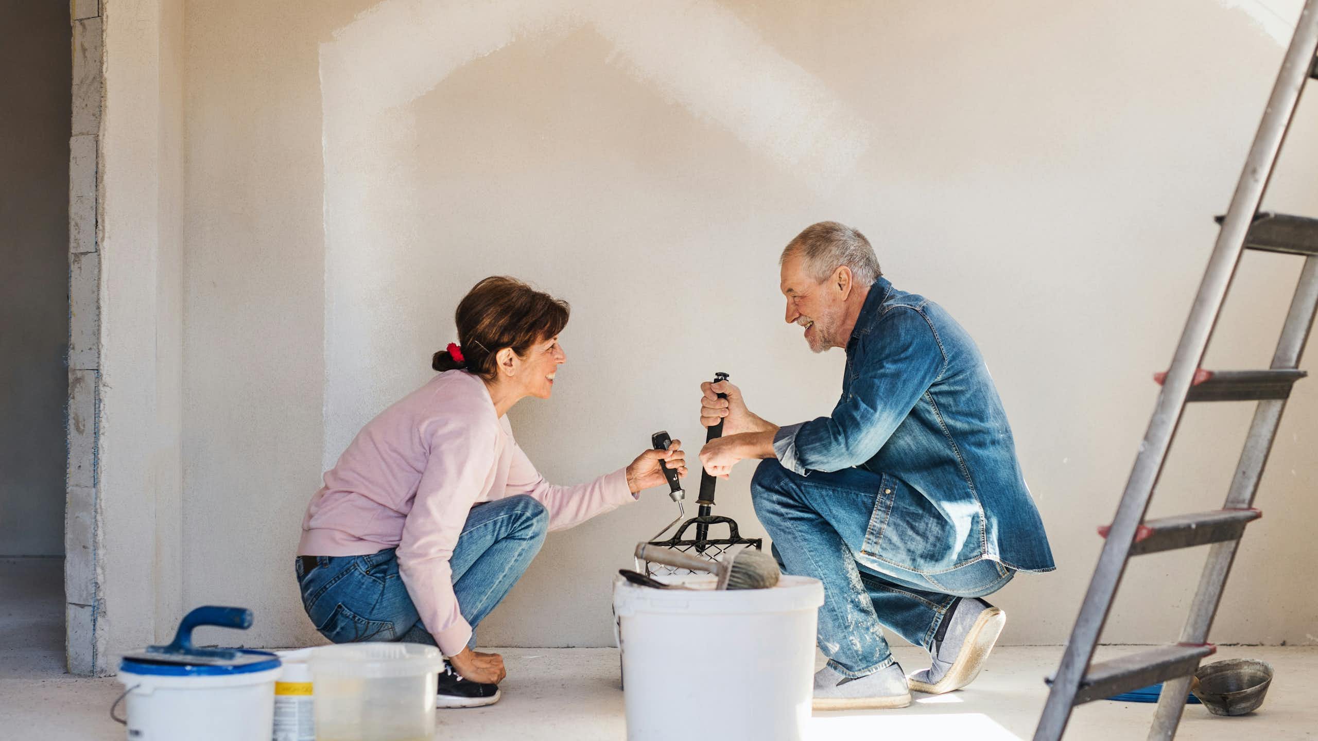 Un couple en train de peindre un mur