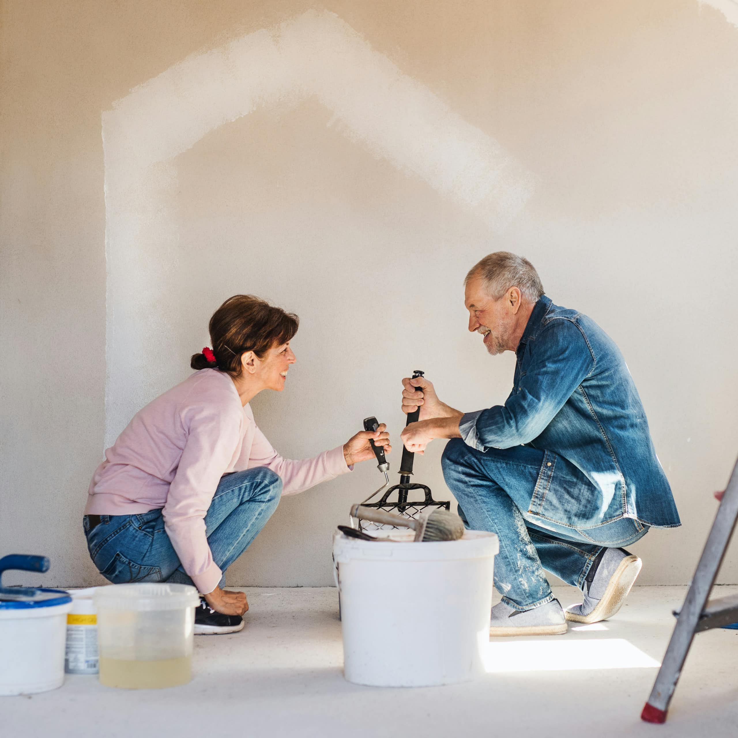 Un couple en train de peindre un mur
