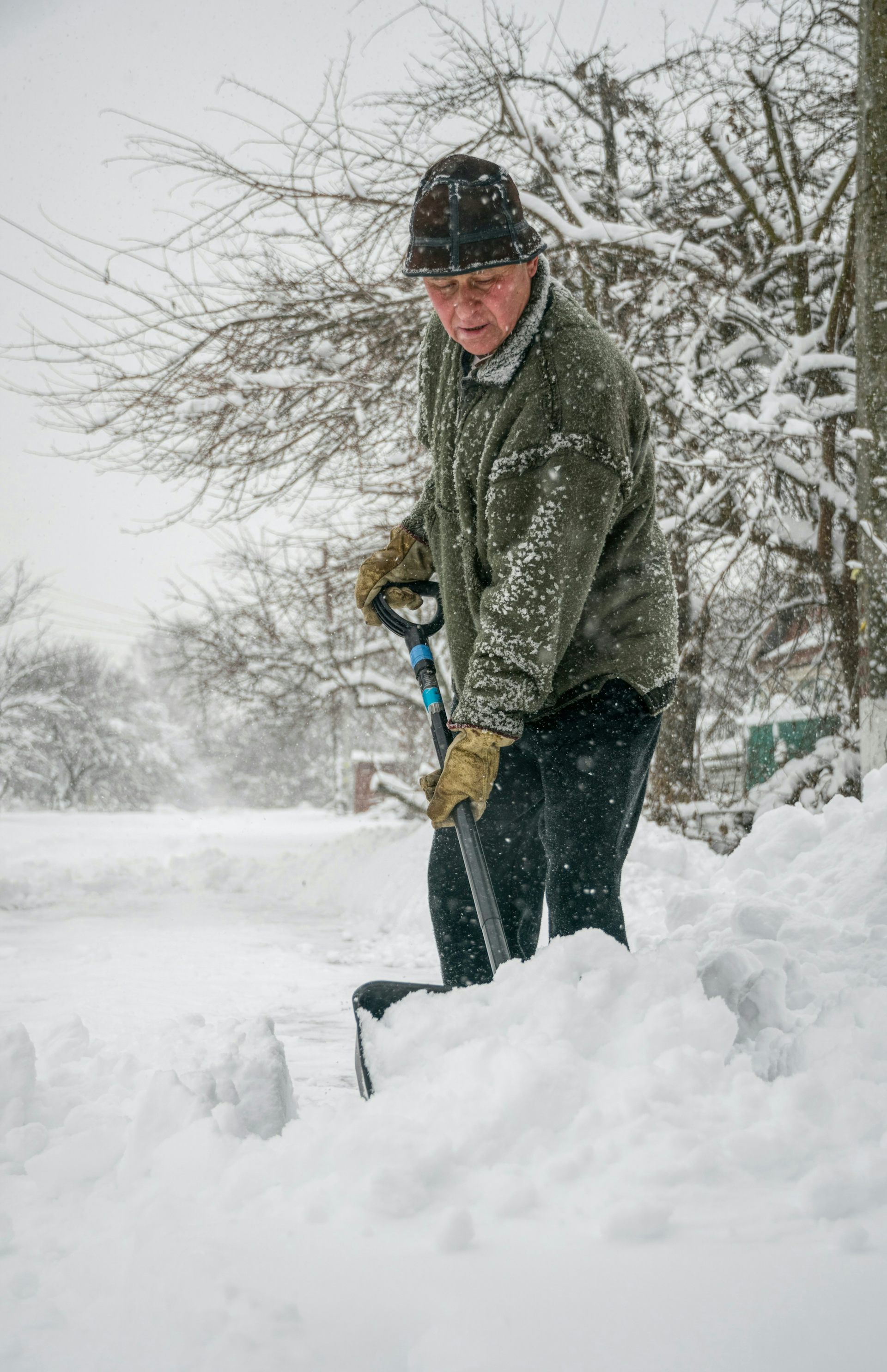 Un homme en train de pelleter de la neige