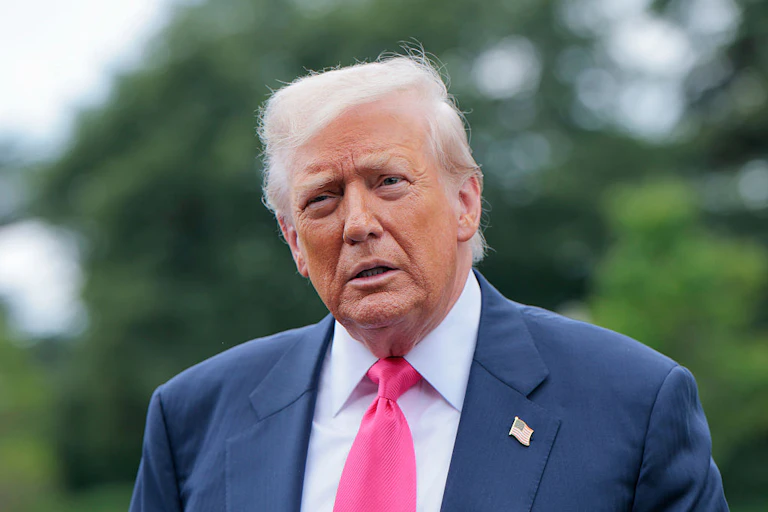 US President Donald Trump outside, trees in background