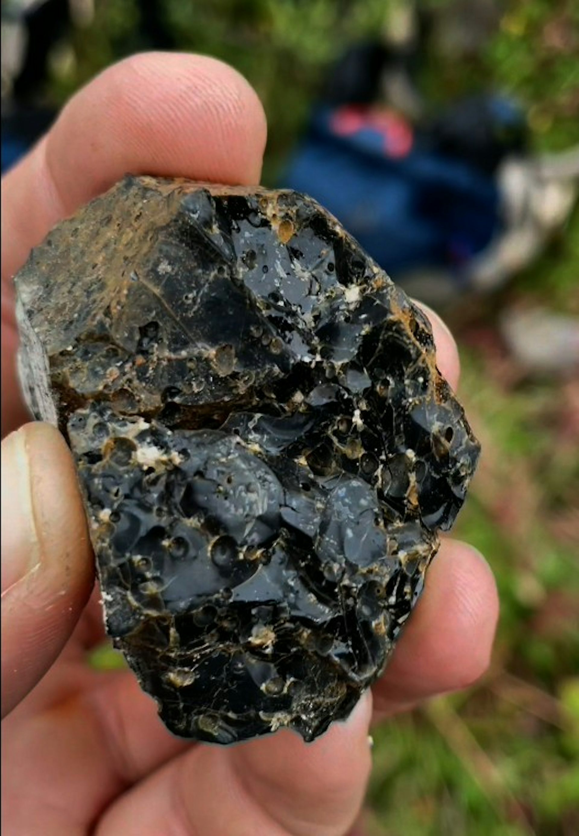 close-up of a hand holding a black rock