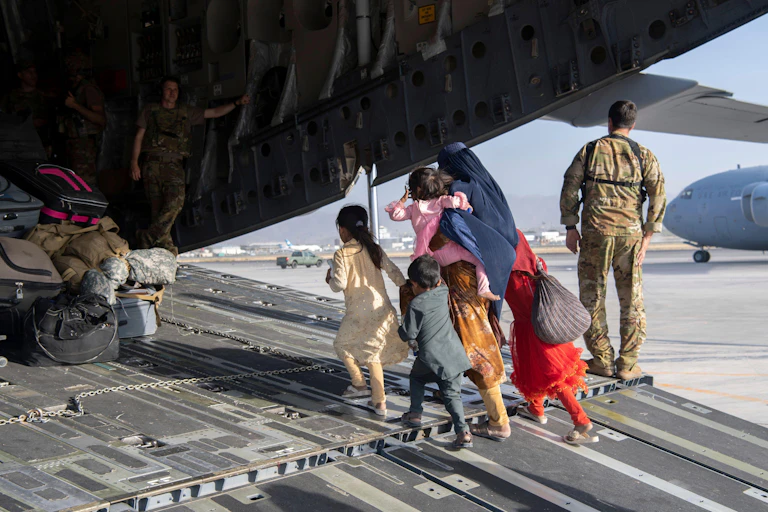 An Afghan family boarding an aircraft for evacuation from Kabul in 2021