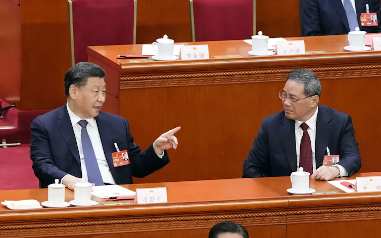 Chinese President Xi Jinping (on left) and Li Qiang at a meeting in Beijing in 2023, both sitting at a desk.