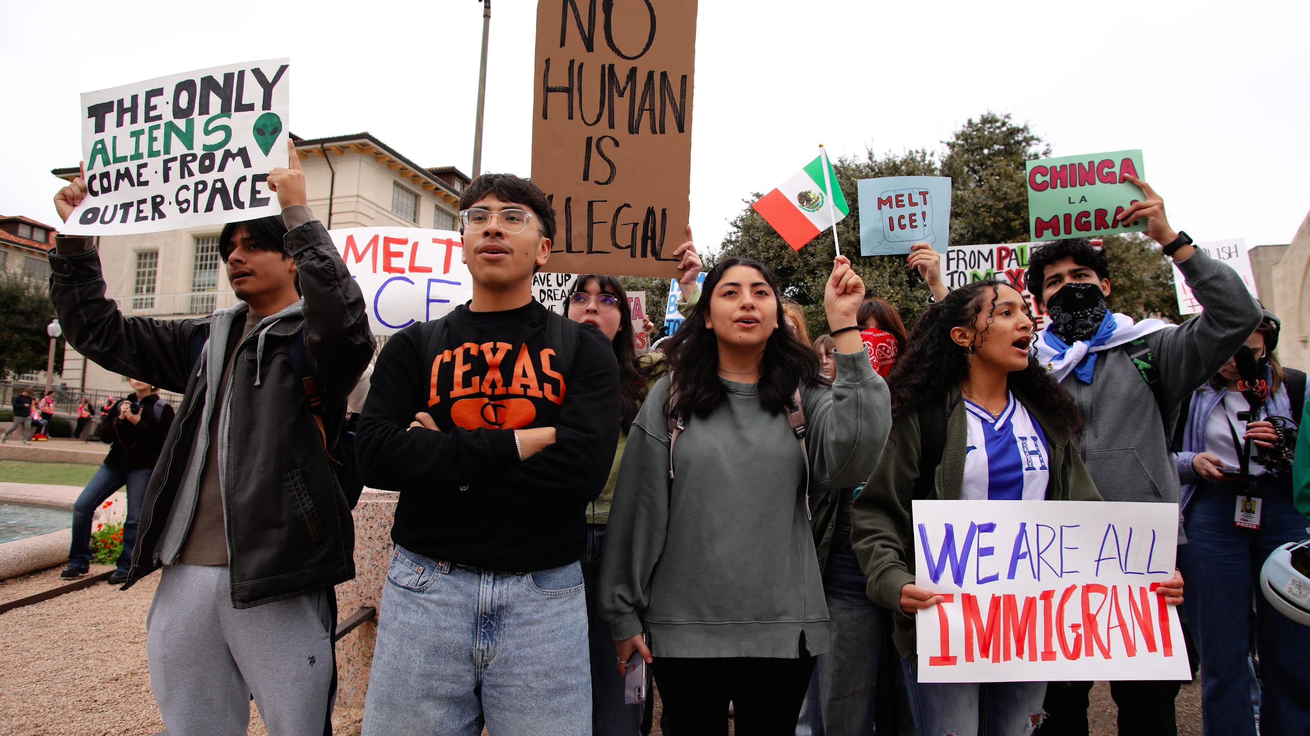 Young people holding up pro-immigration placards at a protest.