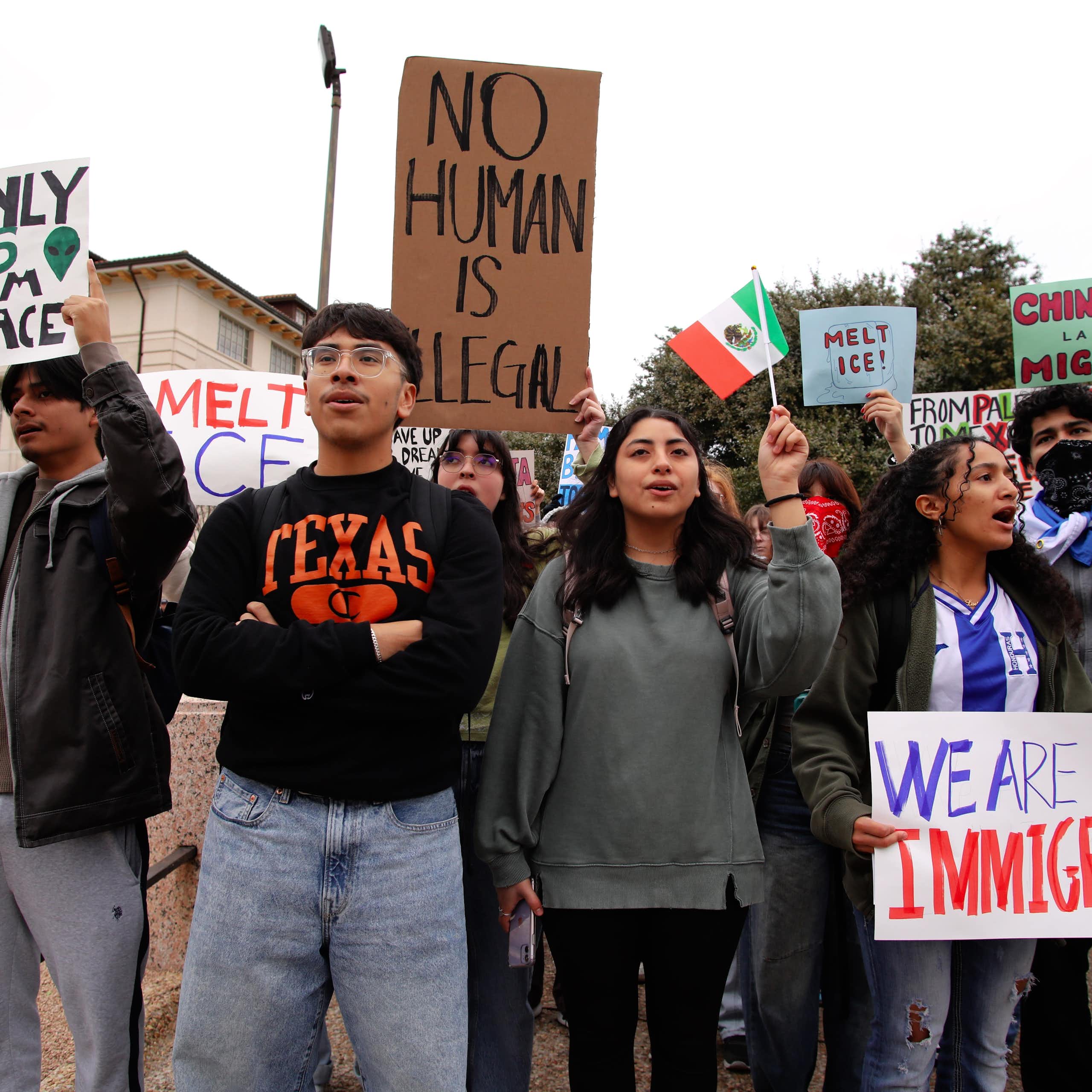 Young people holding up pro-immigration placards at a protest.