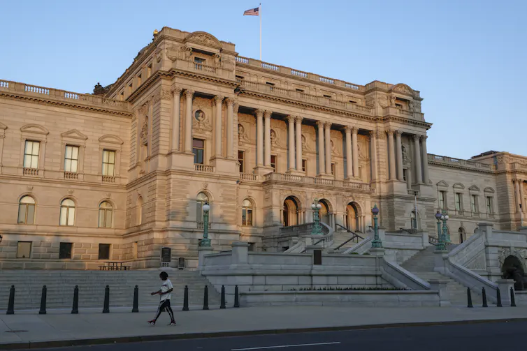 A large building is seen with the sun shining on it on a clear day.