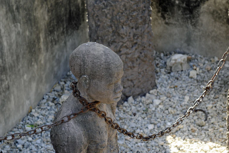 Sculpture of a human head and torso with a chain around its neck