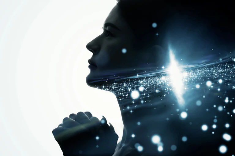Imagen de una persona rezando con estrellas en su interior