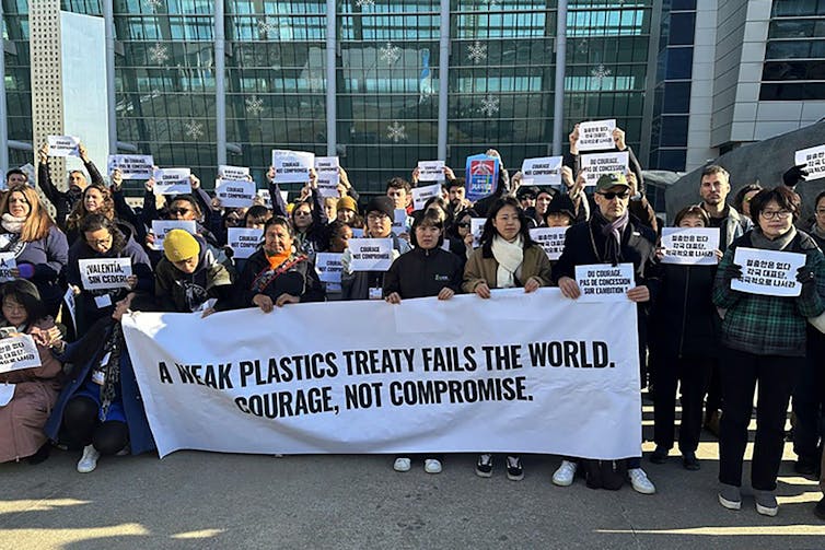 A group of environmental activists protest outside the plastics treaty talks in Busan.