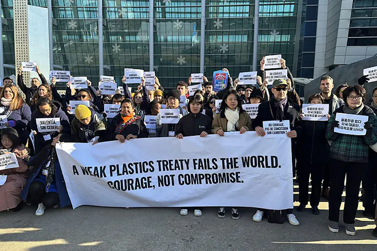 A group of environmental activists protest outside the plastics treaty talks in Busan.
