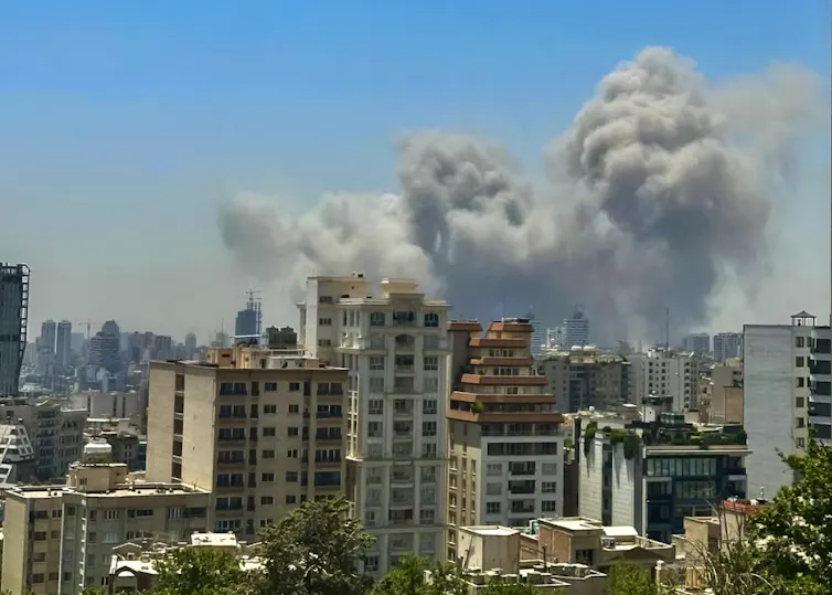 billowing smoke is seen over the top of buildings