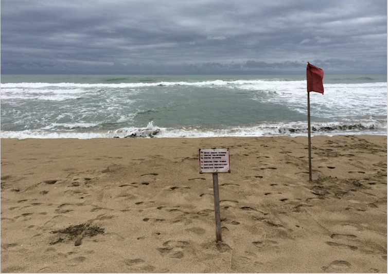 Letreros de playa; Agua oscura entre las olas oceánicas