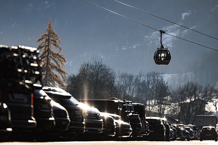 A chairlift above a car park in a ski resort.