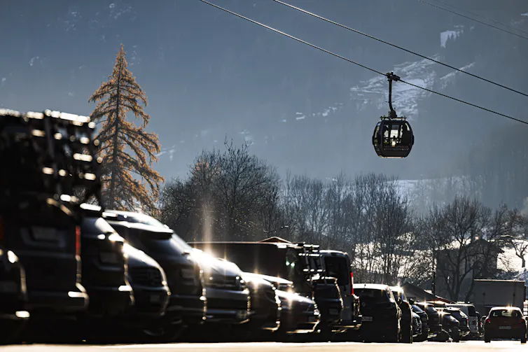 A chairlift above a car park in a ski resort.