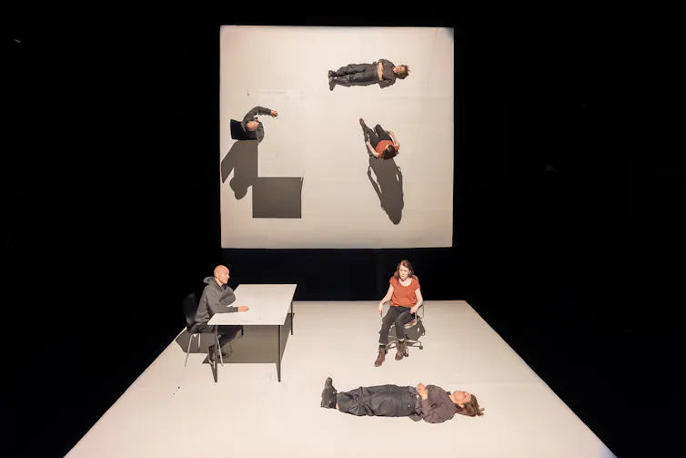 Two stages on which people are sitting at a desk and lying down