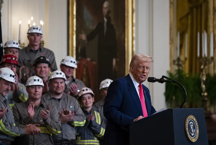 Trump, surrounded by coal-industry representatives, speaks after signing an executive order.