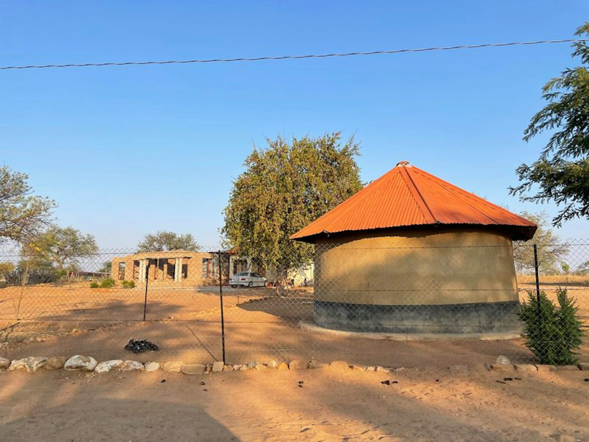 A round home known as a rondavel in South Africa in a barren area