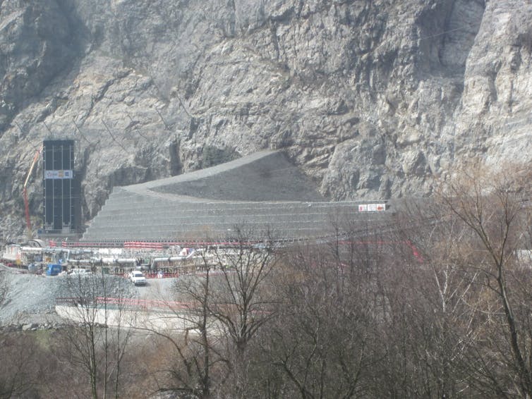 immense construction en béton devant une montagne